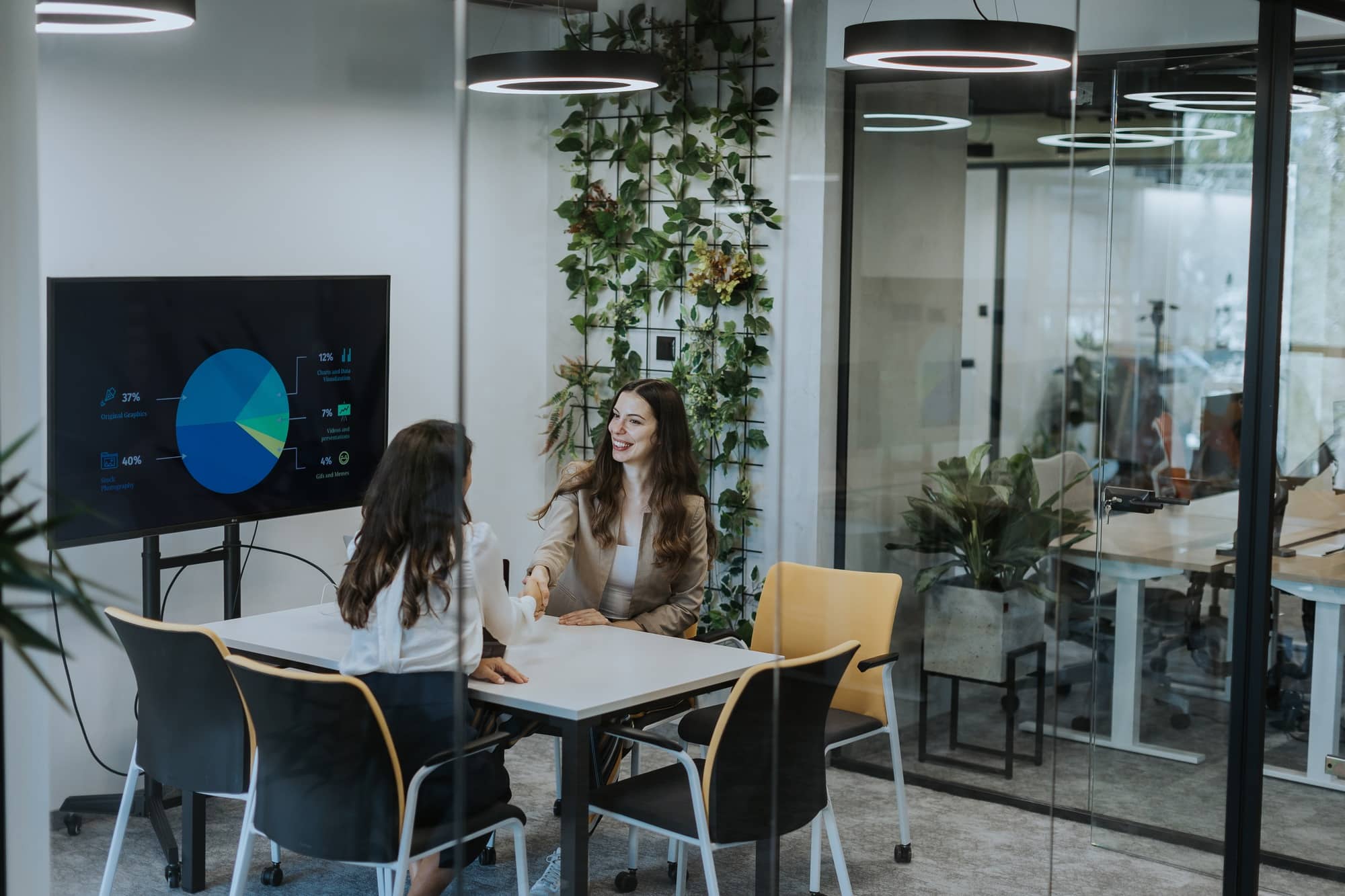 Young business women discussing in cubicle at the office